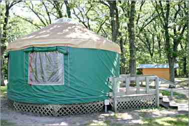 A green canvas-sided yurt looks over Clear Lake in Iowa.