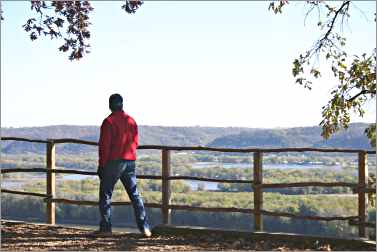 A hiker enjoys the view from Effigy Mounds in Iowa.