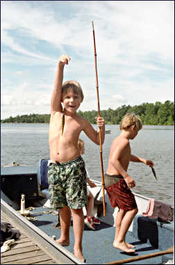 A boy catches a fish.