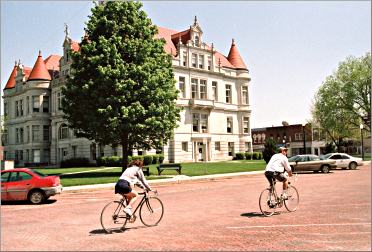Bicyclists ride by the courthouse in Adel, Iowa.