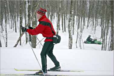 A skier and snowmobiler use trails near Bayfield.