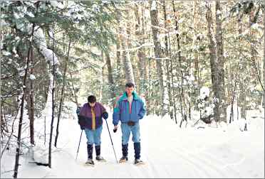 Snowshoers walk through the snowy forest near Bear Paw Outdo