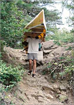 A man portages a canoe in the Boundary Waters.