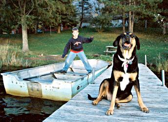 A boy and a dog on a dock near Cable.