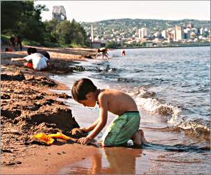 A boy plays in the sand on Park Point.