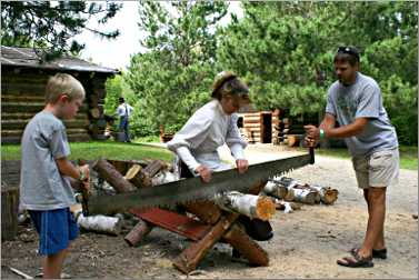 Tourists with a cross-cut saw in Grand Rapids.