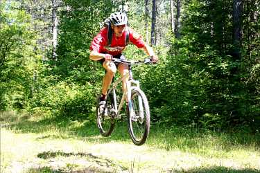 A mountain biker jumps on the trail.