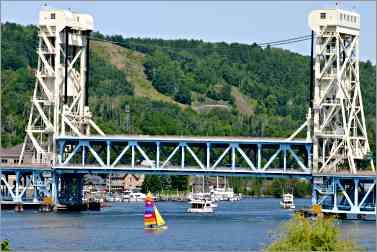 boats sail under lift bridge in Houghton, Mich.