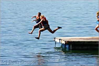 children jumping off raft at Minnesota resort.