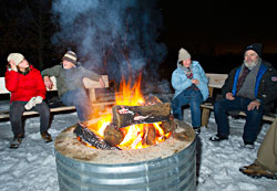 Skiers relax by the bonfire.
