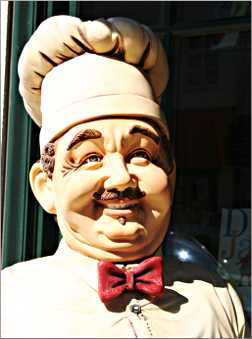 A chef figure outside a restaurant.