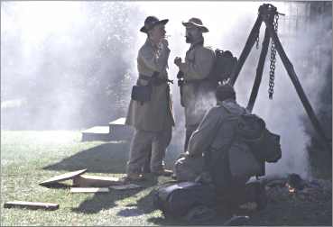 Confederate re-enactors smoke around a fire at Norskedalen.