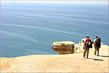 Backpackers stand on a cliff at Pictured Rocks.