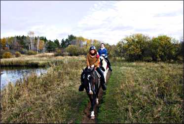 Friends ride horses near Pine River.