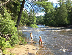 Children wade in the Tahquamenon River.