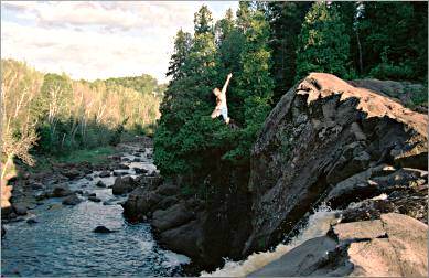 A cliff jumper leaps off Illgen Falls.