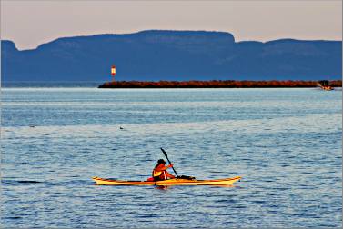 A kayaker paddles off Thunder Bay's marina.