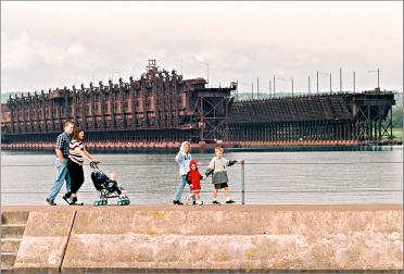 A family walks along the Two Harbors breakwall.