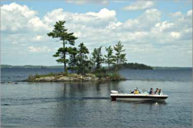A boat speeds past an island on Rainy Lake in Voyageurs Nati