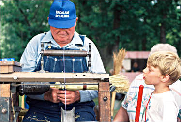 A broom maker demonstrates his craft.